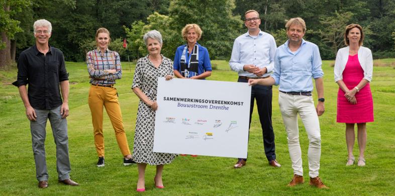 Deelnemers Bouwstroom Drenthe poseren staand naast elkaar met bord die partners laat zien